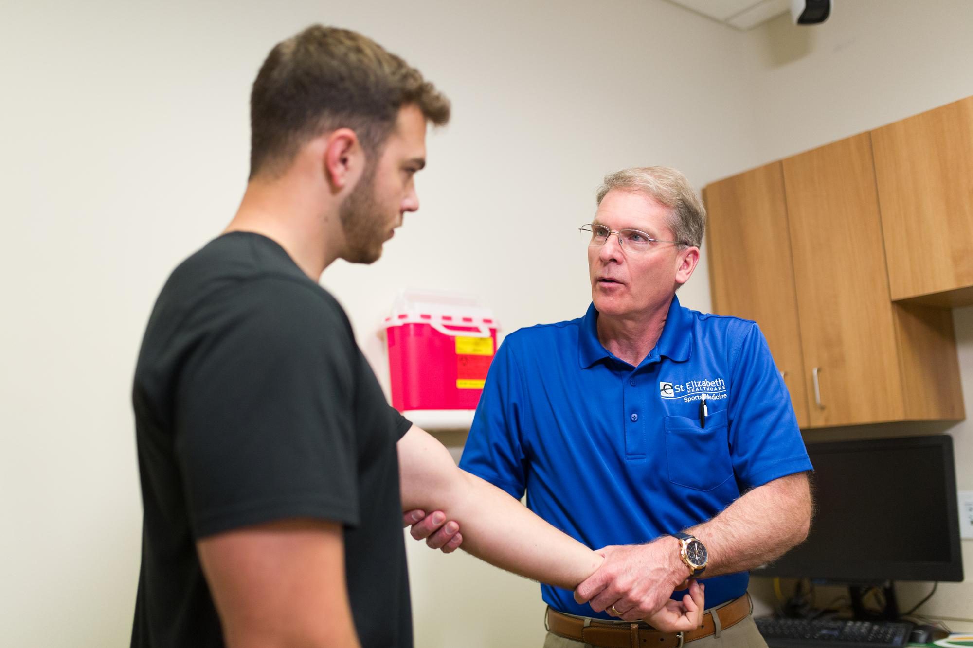Michael Miller – Sports Medicine Dr. Miller exams a athlete's arm.