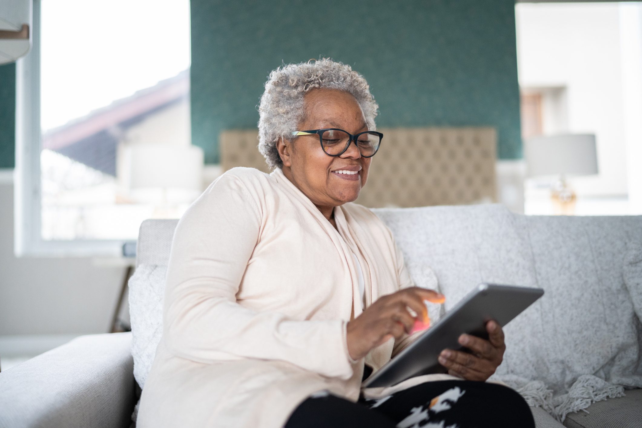 Senior woman using digital tablet at home