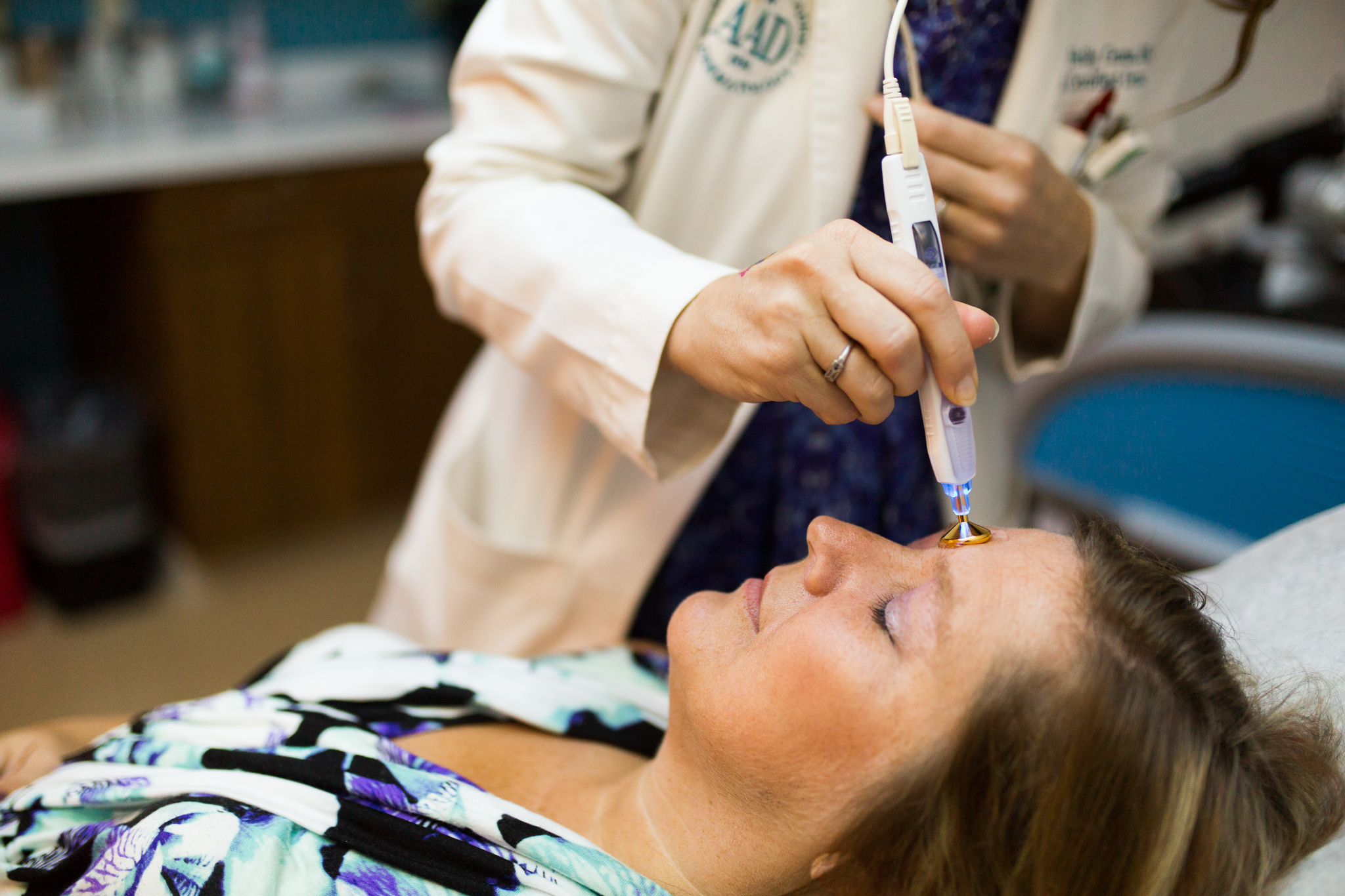 A dermatologist treats the skin of a patient.