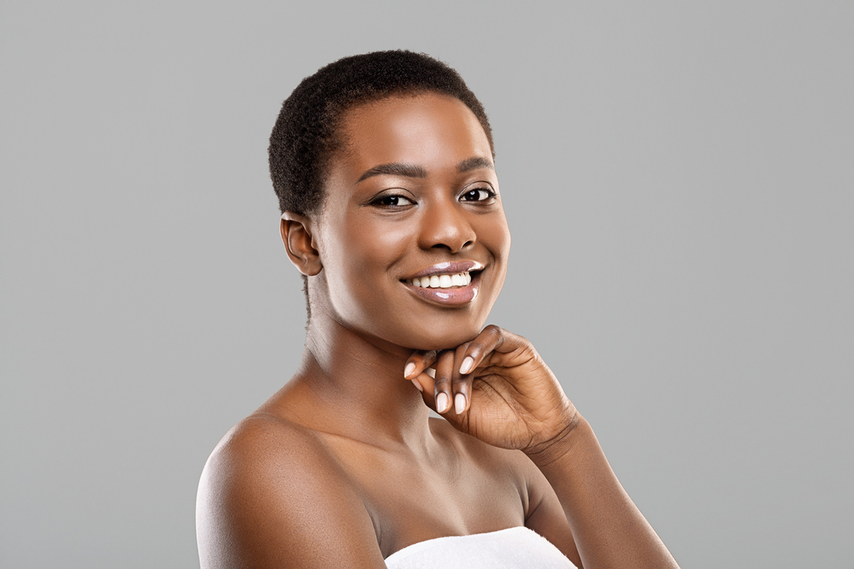 Portrait for woman smiling with hand on chin.