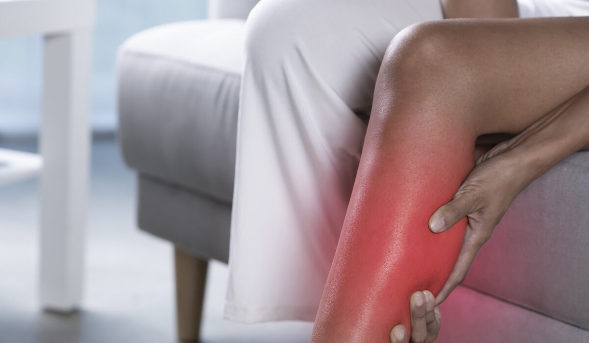 Woman holding the calf with pain. Woman holding painful calf.